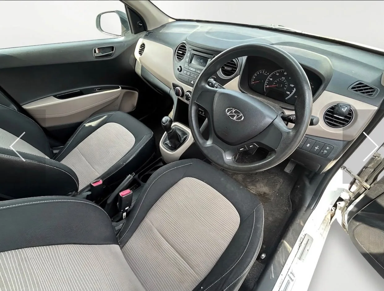 Hyundai i10 front cabin showing dashboard, steering wheel and front seats